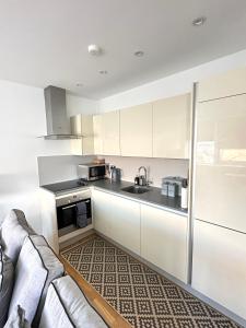 a kitchen with white cabinets and a couch at Holloway Studio in London