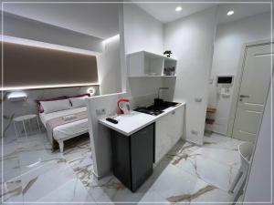 cocina con encimera y habitación con cama en ARIOSTO HOME, en Palermo 11 fotos más