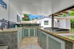 a large outdoor kitchen with a grill and a counter at The Gardens - Luxury Retreat with Pool & Game Room in Miami Gardens