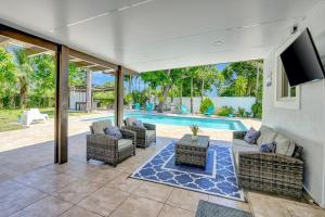 an outdoor patio with chairs and a swimming pool at The Gardens - Luxury Retreat with Pool & Game Room in Miami Gardens
