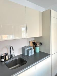 a kitchen with white cabinets and a sink at Holloway Studio in London