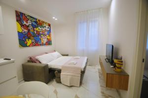 a bedroom with a bed and a table and a tv at ARIOSTO HOME in Palermo