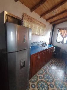 a kitchen with a stainless steel refrigerator and a sink at Mountain Cabin - Nature and Relax in Fúquene