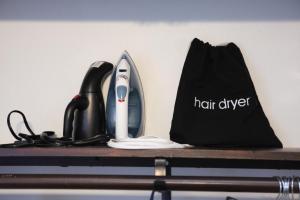 um secador de cabelo e um saco preto sobre uma mesa em Serenity Park Slope - Entire Brownstone apt. em Brooklyn