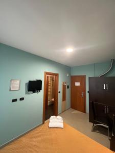 a room with a bed and a tv on a wall at Hotel Residence Sestriere in Moncalieri