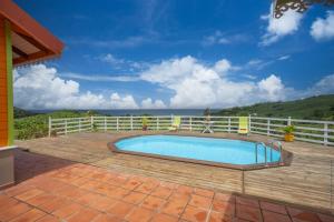 - une piscine sur une terrasse avec l'océan en arrière-plan dans l'établissement Bungalow avec piscine au cœur de la campagne Vert, à Sainte-Marie
