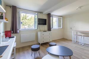 a kitchen with a table and two stools in a room at Maisonnette dans jardin partagé in Colombes