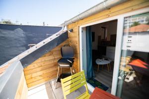 a balcony with a sliding glass door and a chair at Lova Spa Saint-Etienne in Saint-Étienne