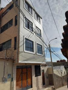 un edificio blanco alto con puertas naranjas. en Urpi Wasi Backpackers, en Puno