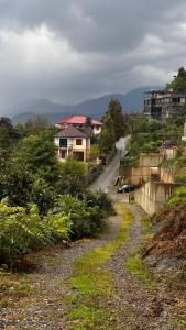 eine unbefestigte Straße, die zu einem Haus auf einem Hügel führt in der Unterkunft OLEG GORGILADZE in Batumi