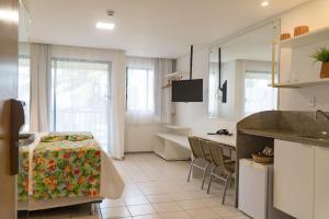 a kitchen with a table and chairs in a room at Marulhos Suítes Resort by MAI in Porto De Galinhas