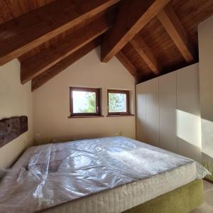 ein großes Bett in einem Zimmer mit Holzdecken in der Unterkunft Baita Dinh - Villaggio dei Crodini in Crodo