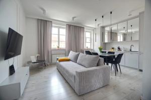 a living room with a couch and a dining room at Warsaw Premium Apartments Old Town in Warsaw