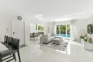 Una sala de estar blanca con un sofá y una mesa. en 10 mins from Pompano Beach! With pool access, en Pompano Beach
