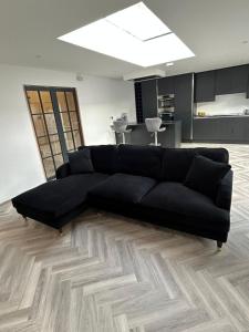 a black couch sitting in a living room at 128 Anfield Road in Liverpool