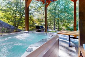 a jacuzzi tub in a cabin with a table at River Rock Cottage in Boone