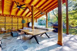 a wooden pavilion with a table and a grill at River Rock Cottage in Boone