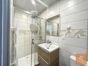 uma casa de banho branca com um lavatório e um chuveiro em Le blue Lagoon - 2 pers - Arrivée Autonome em Châtellerault