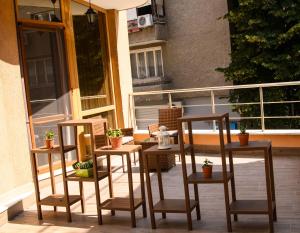 2 chaises et une table sur un balcon avec des plantes en pot dans l'établissement City Zen, à Ruse