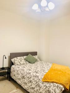 um quarto com uma cama e uma ventoinha de tecto em Cosy 2 bedroom apartment in Swiss Cottage. em Londres