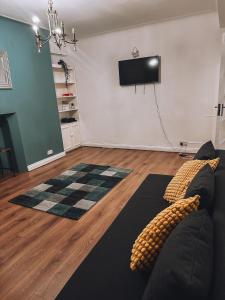 a living room with a couch and a flat screen tv at Cosy 2 bedroom apartment in Swiss Cottage. in London