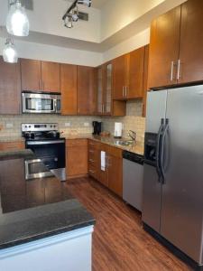 a kitchen with wooden cabinets and a stainless steel refrigerator at The Bentler #1 in Houston