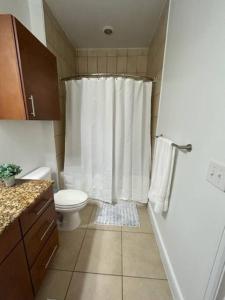 a bathroom with a toilet and a shower with a shower curtain at The Bentler #1 in Houston