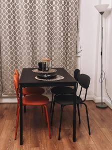 a black table with chairs and a plate of food on it at Cosy 2 bedroom apartment in Swiss Cottage. in London