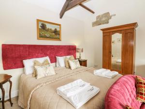 a bedroom with a large bed with two towels on it at Sheep Pen Cottage in Durham
