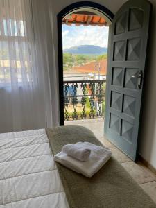 a room with a bed and a door with a view at Pousada Encanto de Tiradentes in Tiradentes
