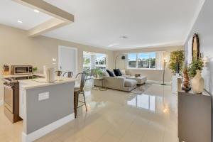 Una cocina y una sala de estar con un sofá y una mesa. en Sunny Pompano Beach with pool access, en Pompano Beach