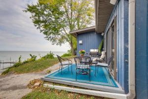 een blauw huis met een tafel en stoelen op de veranda bij Spacious Waterfront Retreat Near UW-Green Bay in Green Bay