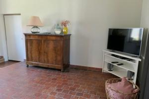 ein Wohnzimmer mit einem TV und einem Tisch mit einer Lampe in der Unterkunft La Cense - Mélin in Jodoigne