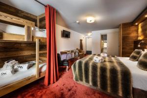 a bedroom with two bunk beds and a red carpet at Hôtel Ski Lodge - Chambres & Appartements - Village Montana in Val-d'Isère +60 photos