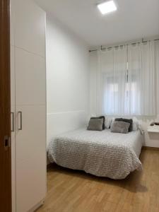 1 dormitorio blanco con 1 cama y armario blanco en Centro Monumental, en Pontevedra