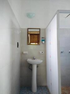 uma casa de banho branca com um lavatório e um chuveiro em Topche, Centro Ecoturístico em Lacanjá