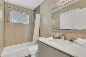 Un baño con un lavabo blanco y un inodoro. en Bright Pompano Beach with pool access, en Pompano Beach 16 fotos más