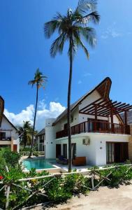 a house with a palm tree and a swimming pool at Ocean View Villa with pool, Zanzibar in Pingwe