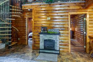 a living room with a fireplace in a log cabin at Secluded Cabin with On-Site Creek and Trails! 