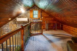 an attic room with a staircase in a log cabin at Secluded Cabin with On-Site Creek and Trails! 