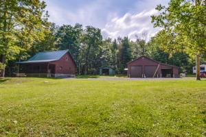 a red barn with a green roof in a field at Secluded Cabin with On-Site Creek and Trails! 