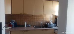een keuken met witte kasten en een wastafel bij Friends Hostel in Tirana