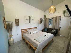 Nueva San SalvadorCasa Serena B&B的带床和沙发的卧室