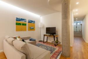 a living room with a couch and a tv at Casa do Alcaide - Minhos Guest in Braga