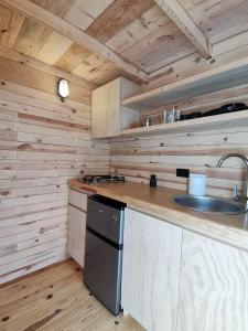 uma cozinha com um lavatório e um fogão em Bosques del Cielo em Los Lirios