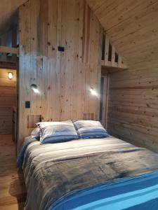 uma cama grande num quarto com paredes de madeira em Bosques del Cielo em Los Lirios