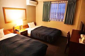 um quarto de hotel com duas camas e uma janela em HOTEL THE NEXT KANKU em Sennan