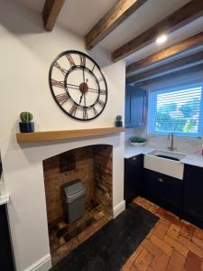 a kitchen with a large clock on the wall at 2 Bed Cottage, Houghton on the Hill, Leicestershire 