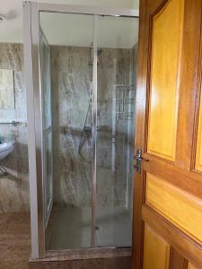 a shower with a glass door in a bathroom at Maison Marikel in Mahe