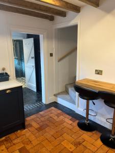 a room with a counter and a table and a staircase at 2 Bed Cottage, Houghton on the Hill, Leicestershire in Houghton on the Hill